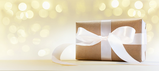 Gift box on a golden background with bokeh. Valentine's day. Holiday of lovers.