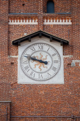 ancient clock on medieval red brick tower, Italy