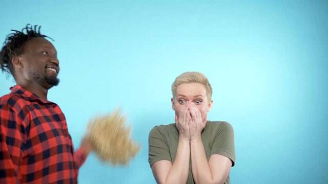 African man and Caucasian woman together. the guy takes off the wig with girls