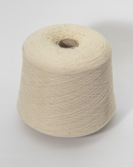 Green bobbin of yarn on a white background.Textile reel on isolated white background.