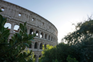 Sun setting behind the Colosseum in Rome, Italy in the warm days of the summer months