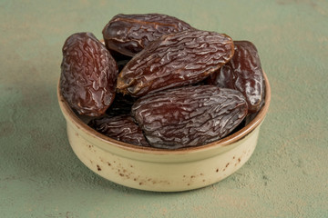 delicious date fruits on green background