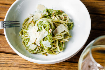 Pasta in a plate with pesto and cheese