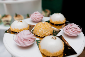 Delicious mousse desserts on the white tray decorated with sweet sprinkles