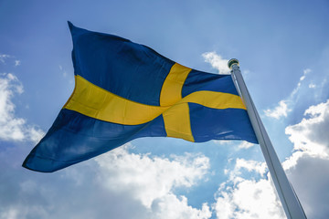 Sweden flag on dark blue sky background.