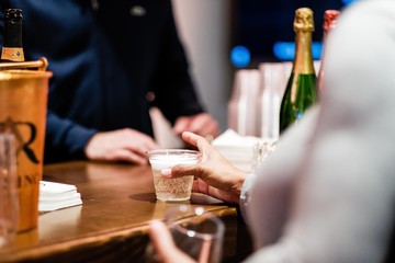 Person grabbing drink from bar