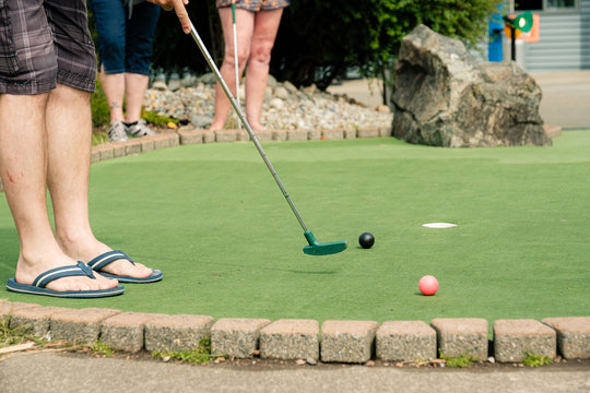 People playing miniature golf