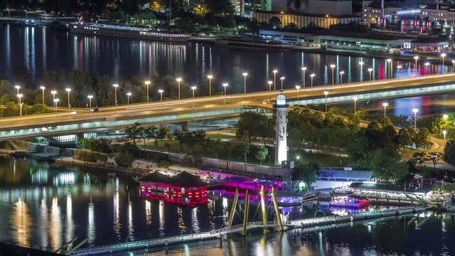 Aerial panoramic view over Vienna city with copa beach, Ponte Kagrana footbridge and a riverside promenade night timelapse in Austria. Illuminated skyline from Danube Tower viewpoint