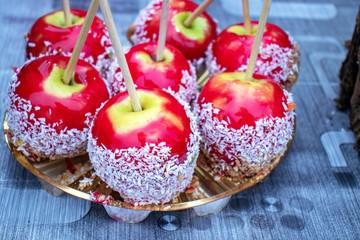 Apples in caramel and coconut. Christmas sweets. City food festival.