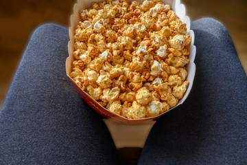 Huge bag of sweet popcorn between knees