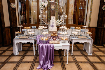 Pompous wedding candy bar and decorated with lavender wedding cake