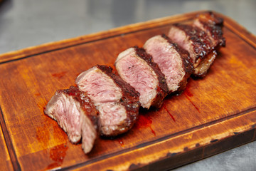 fried ham, cut into slices, lying on a wooden board