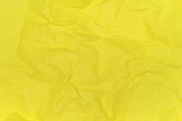 Crumpled paper texture background of yellow colour. View from above.