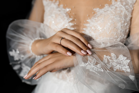 Stylish fatin sleeves with embroidery of a wedding dress and tender hands of a girl