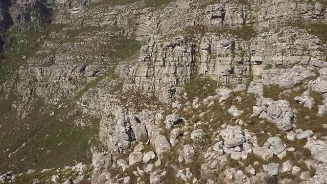 medium wide drone view of Table Mountain rock formation in the late afternoon sun with steep cambrian sandstone rock formations, cliffs, quartzite, and tectonic lines of the Cape Supergroup.