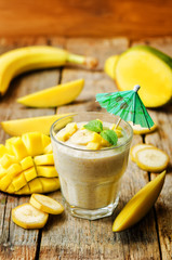 banana mango smoothie on a wood background