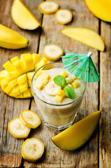 banana mango smoothie on a wood background