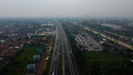 Obraz premium BEKASI, WESTJAVA, INDONESIA : JANUARY 10 202 : Aerial drone view of highway multilevel junction road with moving cars after rainy. Cars are blurred