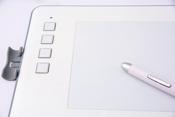 Modern white graphic tablet for drawing with pen close-up. Modern white graphic tablet for drawing...