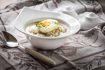 Sorrel soup with egg in white bowl.