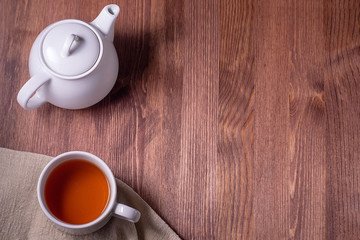 Tea. Cup of tea and teapot on a dark wooden table. Top view, copyspace