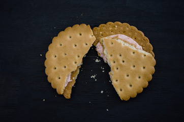 sandwich crackers on a black background. Pieces and crumbs of cookies. Close-up.