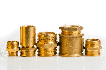 Row of brass fitting on white wet workshop table