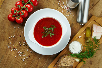 Homemade and tasty Ukrainian borsch with sour cream in a bowl on a wooden background. Ukrainian cuisine. Copy space food photography. red soup