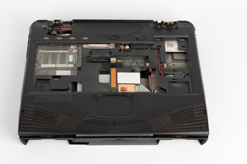 old laptop, removed monitor , keyboard, battery and  floppy disk drive on white background