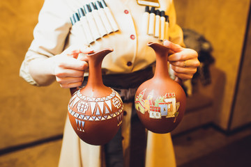 delicious georgian lavash with glass of beverage and person holding clay jug behind.