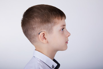 Young boy wearing a hearing aid. Studio shot. 