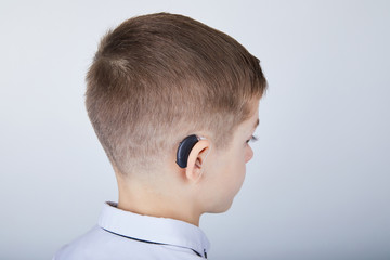 Young boy wearing a hearing aid. Studio shot. 