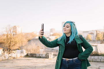 Happy girl with dimples taking selfie outdoors