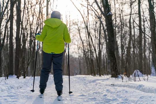 A Ski Boy Stands With His Back To The Camera Against The Background Of A Frosty Winter Forest