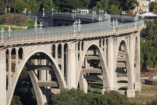 The Colorado Street Bridge is shown spanning the Arroyo Seco (dry stream) in Pasadena, California, USA during the day. The concrete arch bridge was completed in 1913.