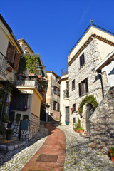 Fototapeta premium A narrow street between the old houses of a medieval town in Italy