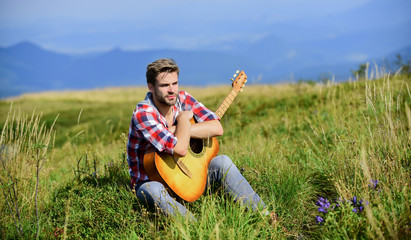 Naklejka na ściany i meble Wanderlust concept. Inspiring nature. Summer vacation highlands nature. Musician looking for inspiration. Dreamy wanderer. Pleasant time alone. Peaceful mood. Guy with guitar contemplate nature