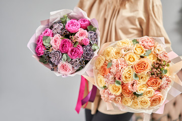European floral shop. Two Beautiful bouquets of mixed flowers in womans hands. the work of the florist at a flower shop. Delivery fresh cut flower.