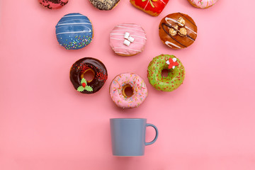 Colorful Donuts with icing and coffe cups on pastel rose background. Sweet donuts.