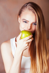 young pretty blond woman holding green apple smiling slim, lifestyle people concept