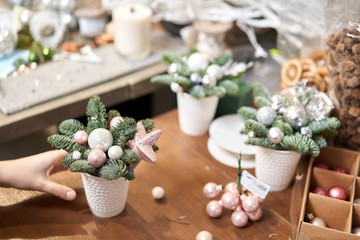 A woman decorates a Christmas arrangement. Master class on making decorative ornaments. Christmas decor with their own hands. The new year celebration. Flower shop