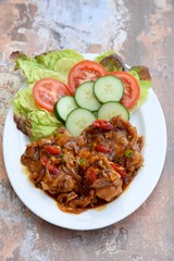 Ayam Kecap. Chicken cooked or stew in thick sweet soy sauce and spices. Served with rice, lettuce, sliced cucumber and tomato