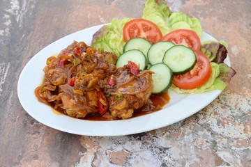 Ayam Kecap. Chicken cooked or stew in thick sweet soy sauce and spices. Served with rice, lettuce, sliced cucumber and tomato