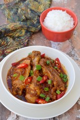 Ayam Kecap. Chicken cooked or stew in thick sweet soy sauce and spices. Garnish with scallions and sliced red chili. Served with steamed rice