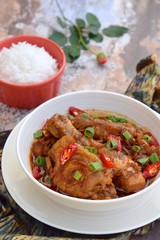 Ayam Kecap. Chicken cooked or stew in thick sweet soy sauce and spices. Garnish with scallions and sliced red chili. Served with steamed rice