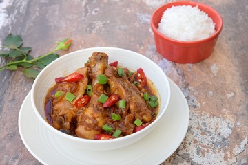 Ayam Kecap. Chicken cooked or stew in thick sweet soy sauce and spices. Garnish with scallions and sliced red chili. Served with steamed rice