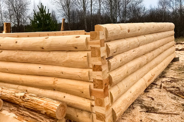 Drying and assembly of wooden log house at a construction base.