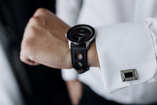 Front view of man's hand with stylish watch and sleeve with cufflinks