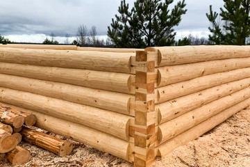 Drying and assembly of wooden log house at a construction base.