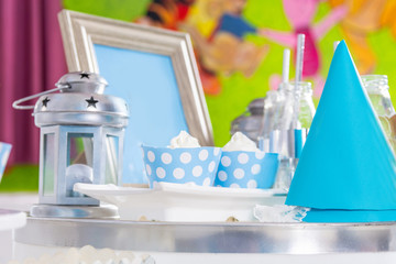 Birthday children sweet table with cupcake and decoration. Desk with sweet birthday party decoration indoor at a restaurant. Close up, selective focus